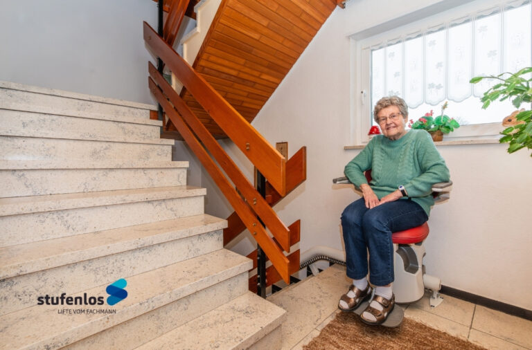 Treppenlift im Wohnhaus mit sitzender Person – Beispiel für Kosten und Einbausituatio