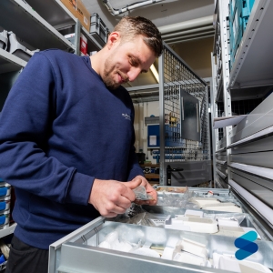 STUFENLOS Servicetechniker entnimmt Ersatzteile aus dem eigenen Teilelager für die Wartung eines Treppenlifts.